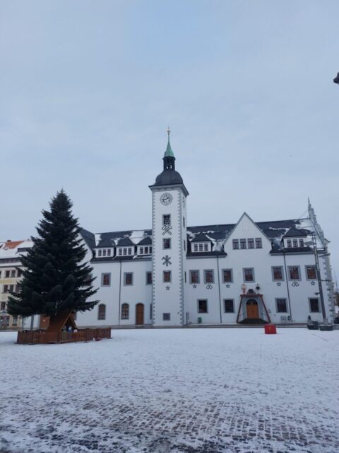 verschneites Rathaus von Freiberg mit Christbaum und Krippe