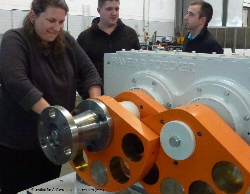 Studentin bewegt einen Unwuchterreger für eine Schwingsiebmaschine von Haver Niagara