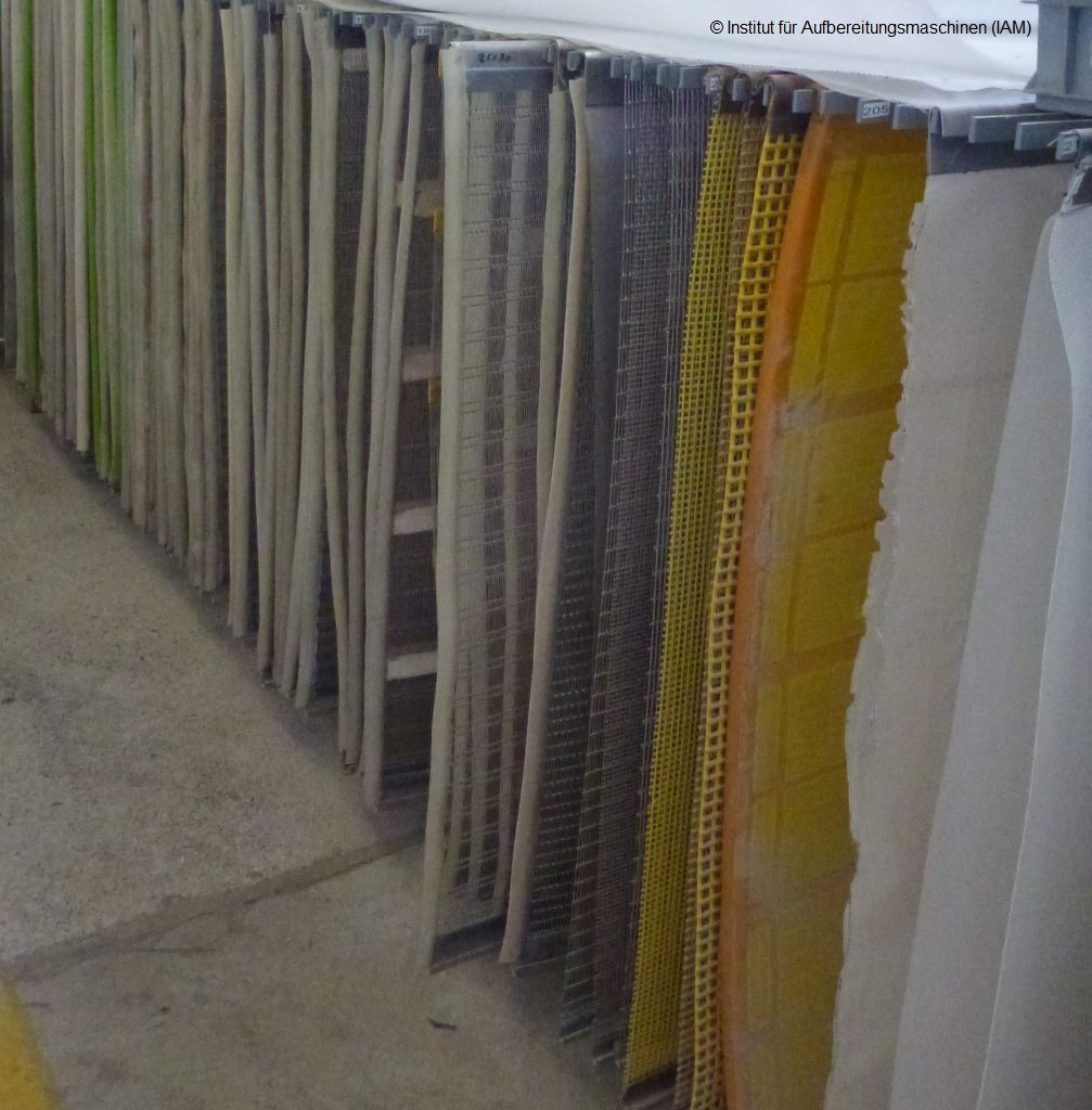 Different types of screen coverings hung up in a row, used by Haver Niagara for various applications