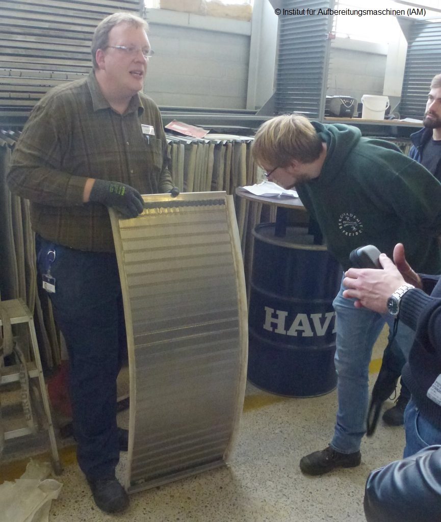 A man demonstrates new screen coverings from Haver Niagara in front of students with special mesh geometries and coverings for demanding screening materials