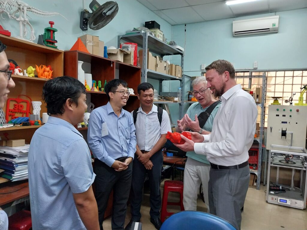 Zwei deutsche Professoren besuchen vietnamesiche Kollegen in einem 3D-Labor